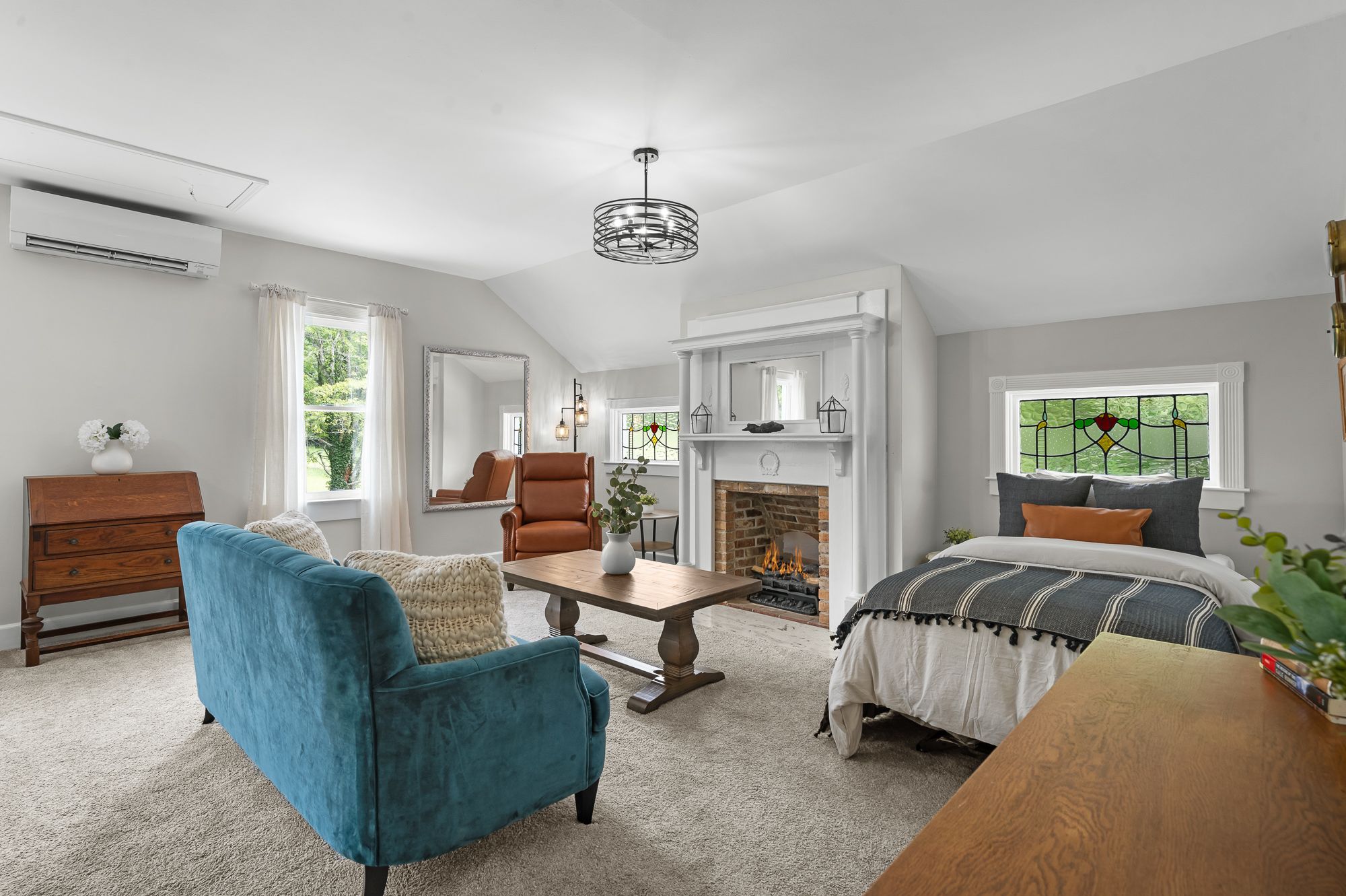 The Seafarer sitting area with armchairs, an electric fireplace and a stained glass window